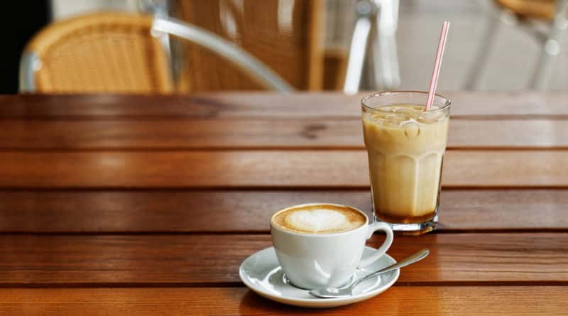 A cup of cappuccino and a glass of iced-latte